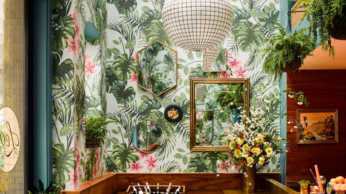 gold framed mirrors tropical pattern wallpaper
