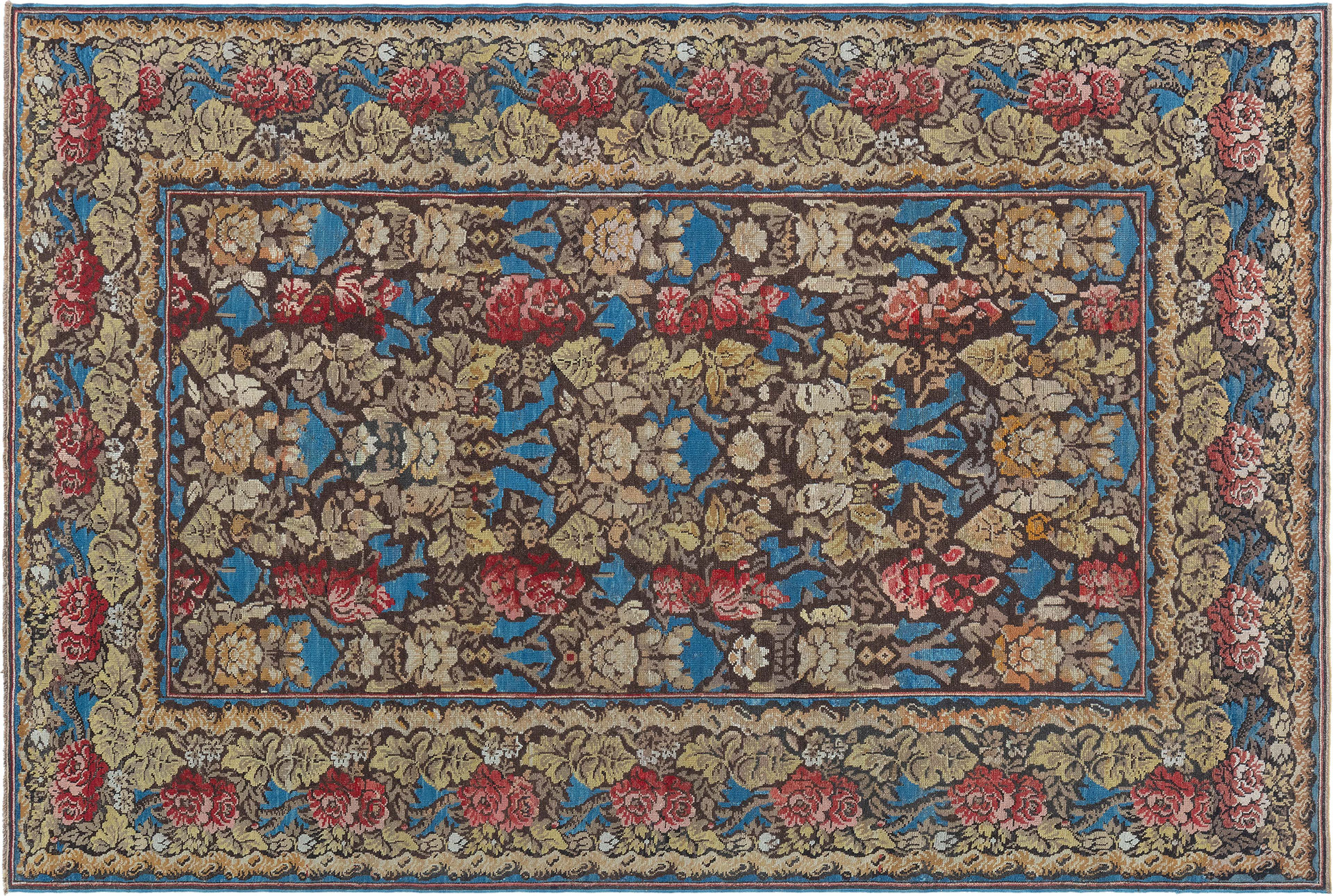 An antique Ukrainian rug with rich floral elements on a sky-blue background